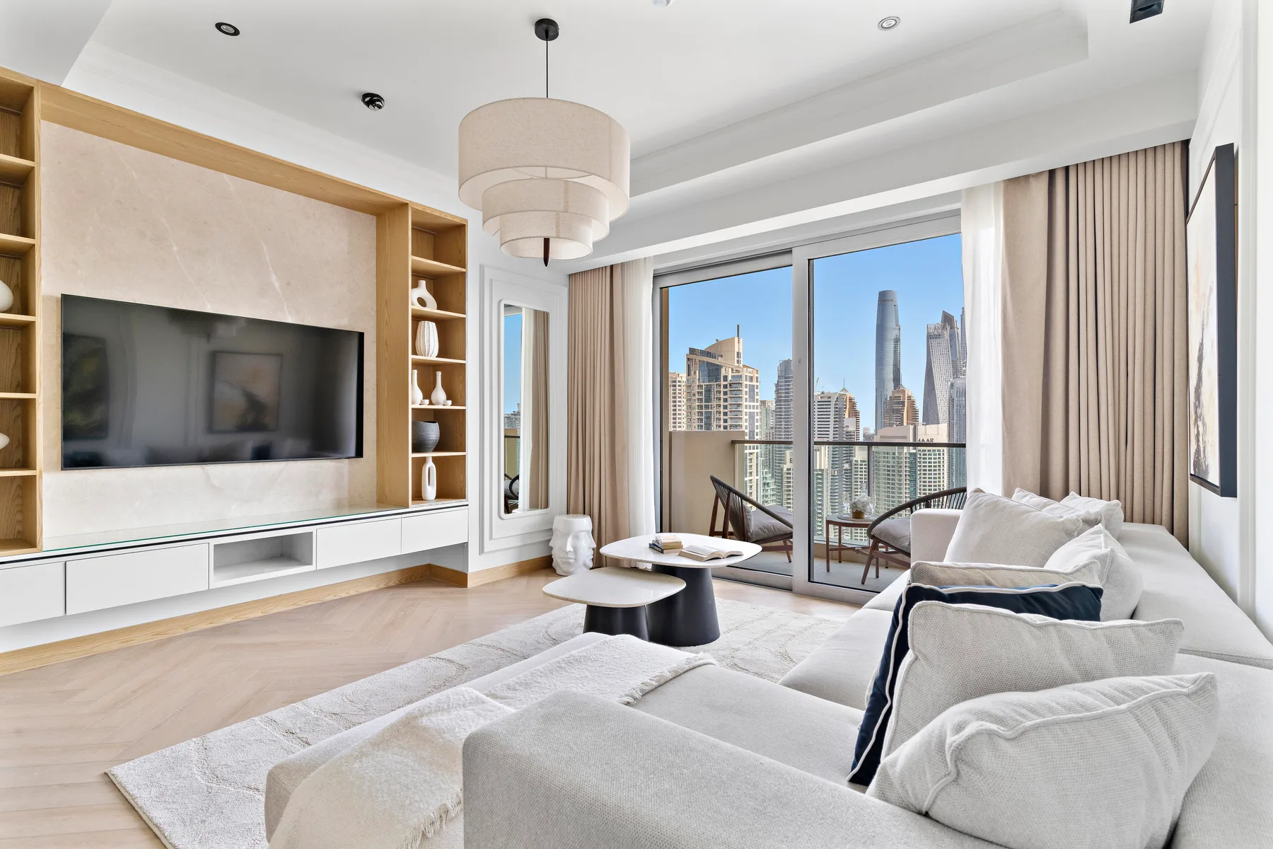 Una sala luminosa con asientos, un televisor y grandes ventanas con vistas a la ciudad.