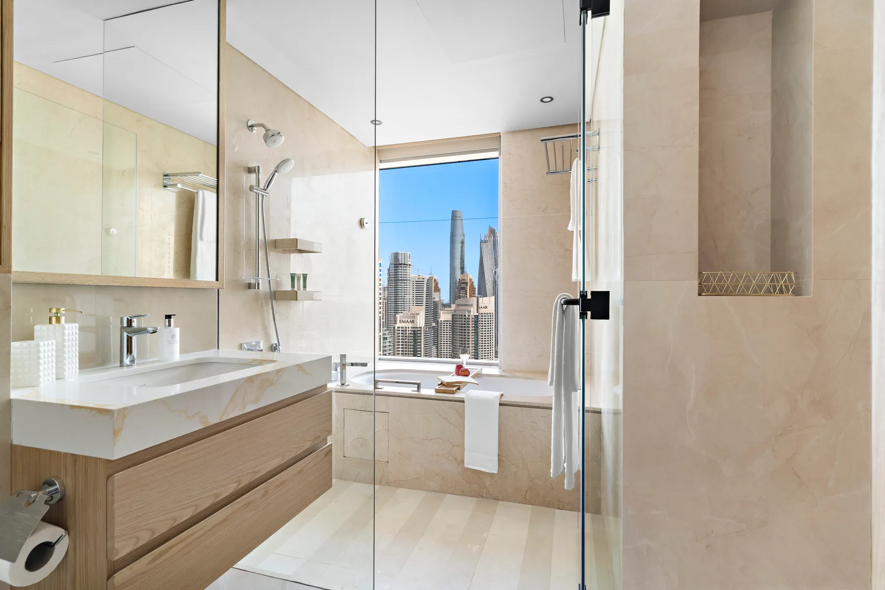 Un baño moderno con una ducha de vidrio y vistas de la ciudad por la ventana.