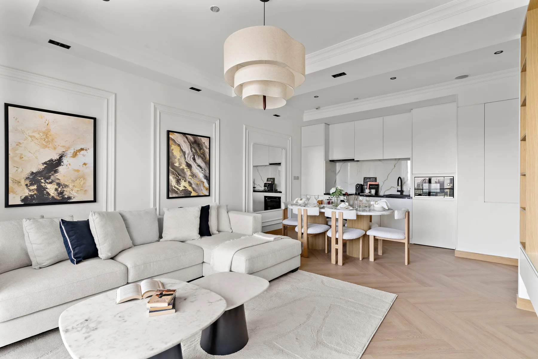 A bright open-plan living room and kitchen with a dining table.