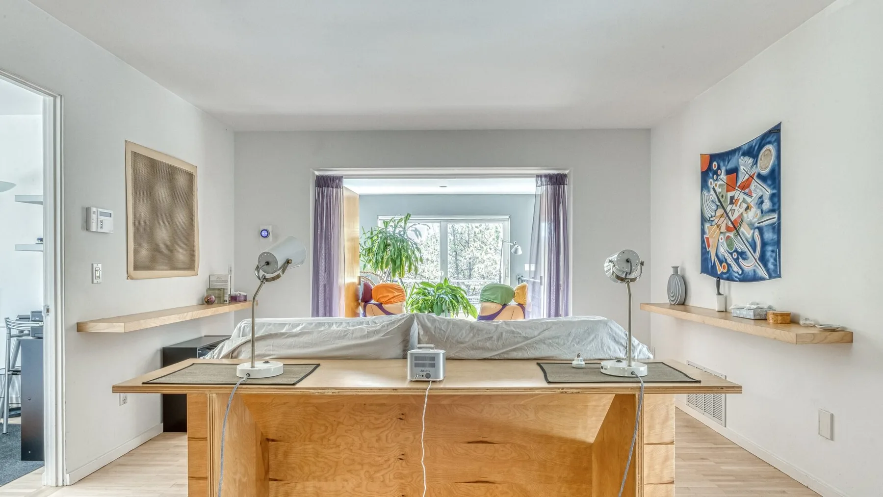 A bright treatment room has a central padded table and large windows.