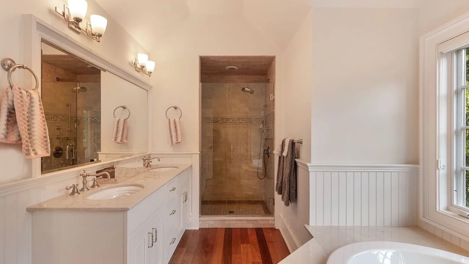 A bathroom with a double vanity, walk-in shower, and soaking tub.