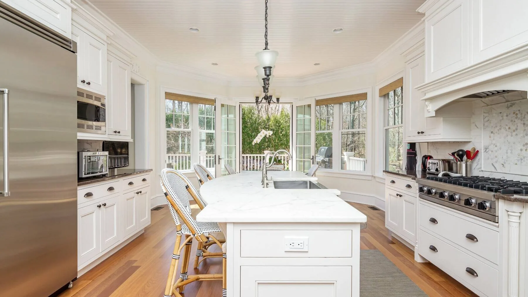 A bright kitchen with a central island and large windows.