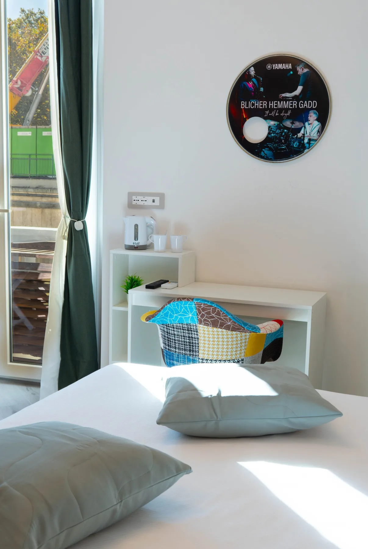 A bright bedroom with a neatly made bed and a colorful basket.