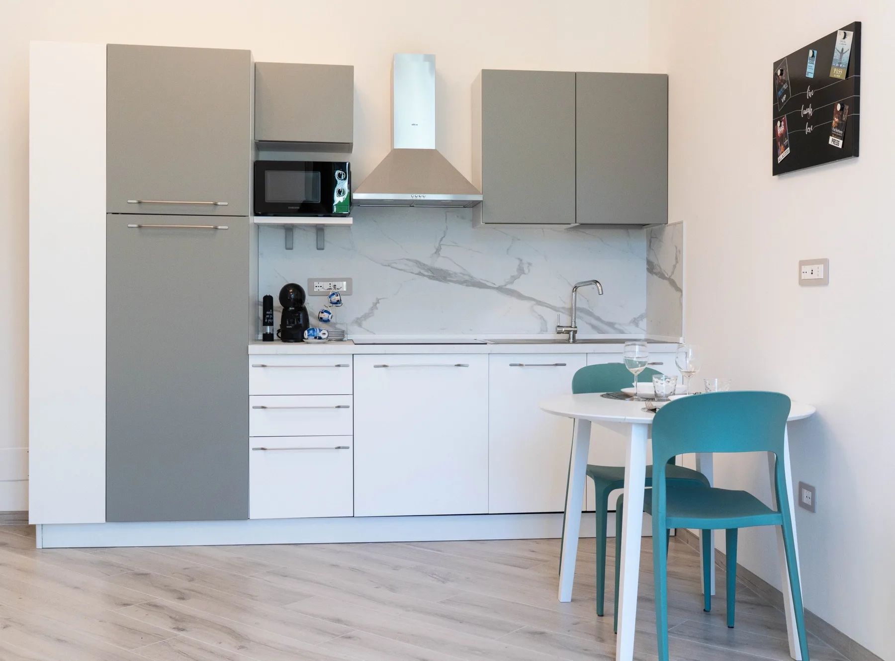 A compact kitchen with gray cabinets and a small dining table.
