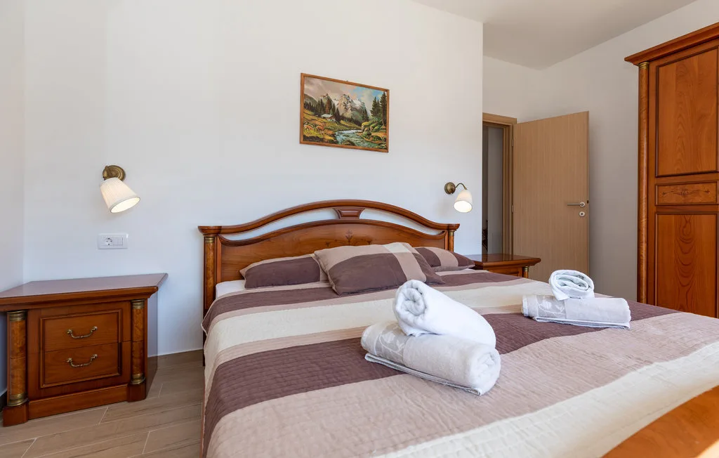 Un dormitorio con una cama bien tendida y muebles de madera.