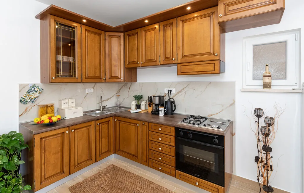 Una cocina con armarios de madera, una encimera y un horno integrado.