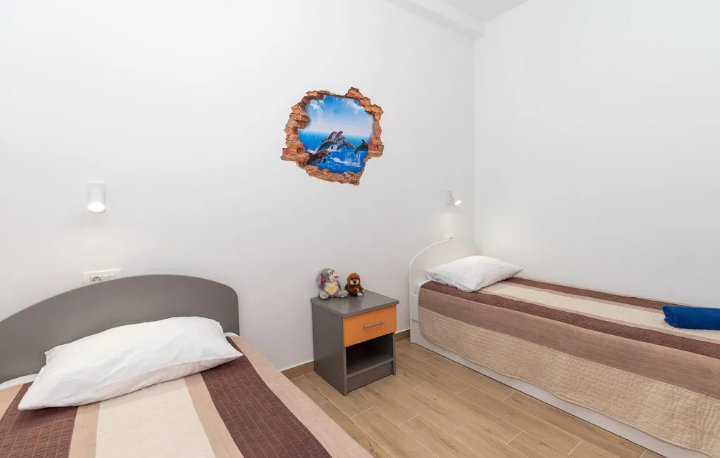 Un dormitorio con dos camas individuales y una pequeña mesita de noche.
