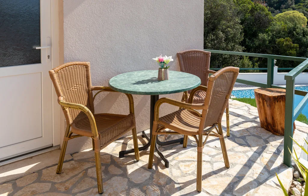 Una zona de estar en el patio con una mesa redonda y vistas a la vegetación.