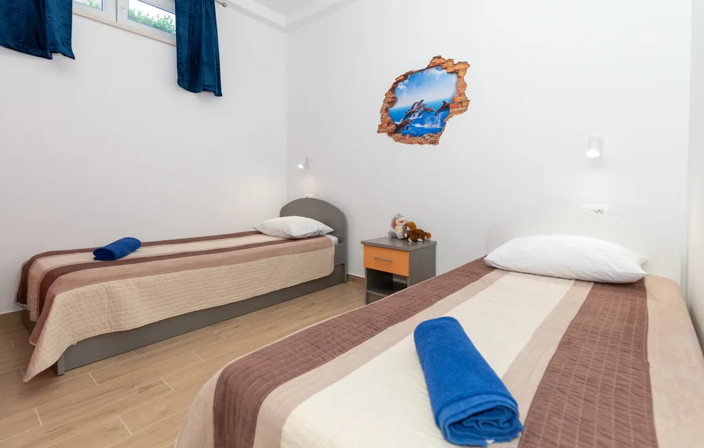 Un dormitorio con dos camas y toallas azules dobladas.