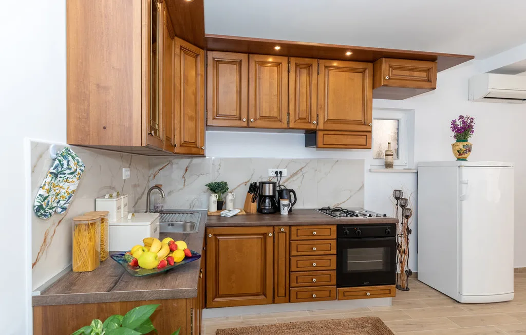 Una cocina con gabinetes de madera, una encimera y electrodomésticos.