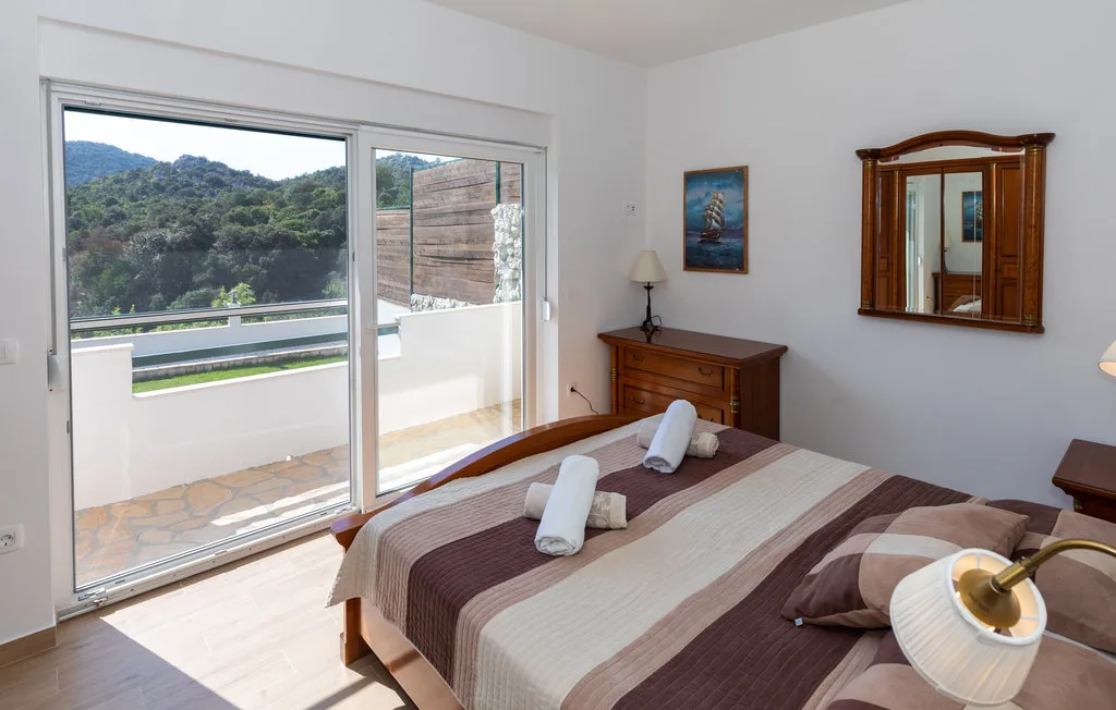 Un dormitorio con una cama doble y puertas corredizas de vidrio que dan a un balcón.