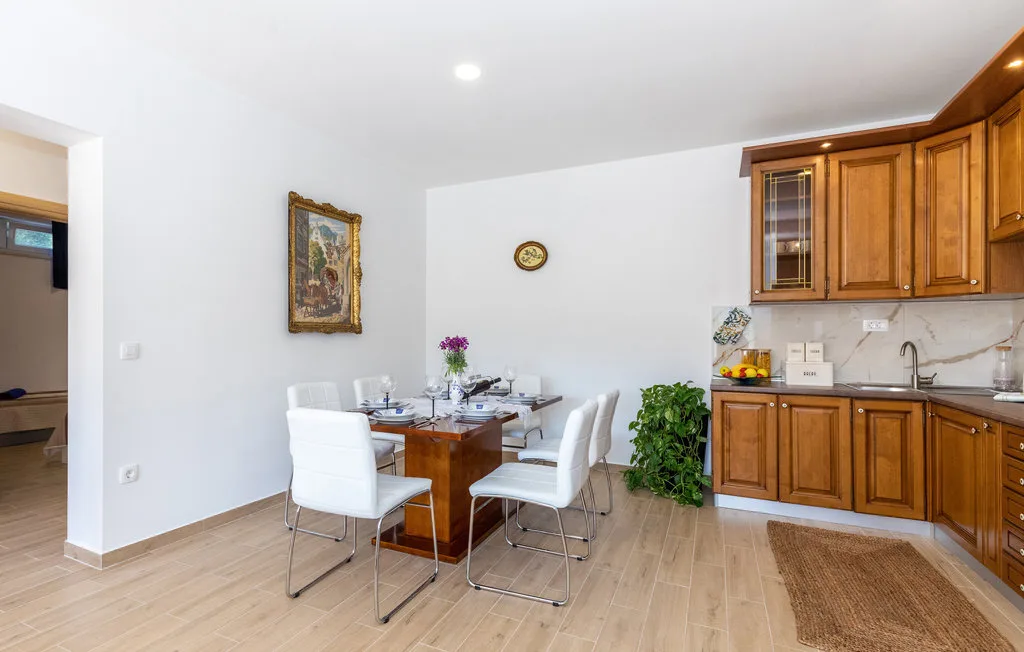 Comedor con la mesa puesta junto a armarios de cocina de madera.