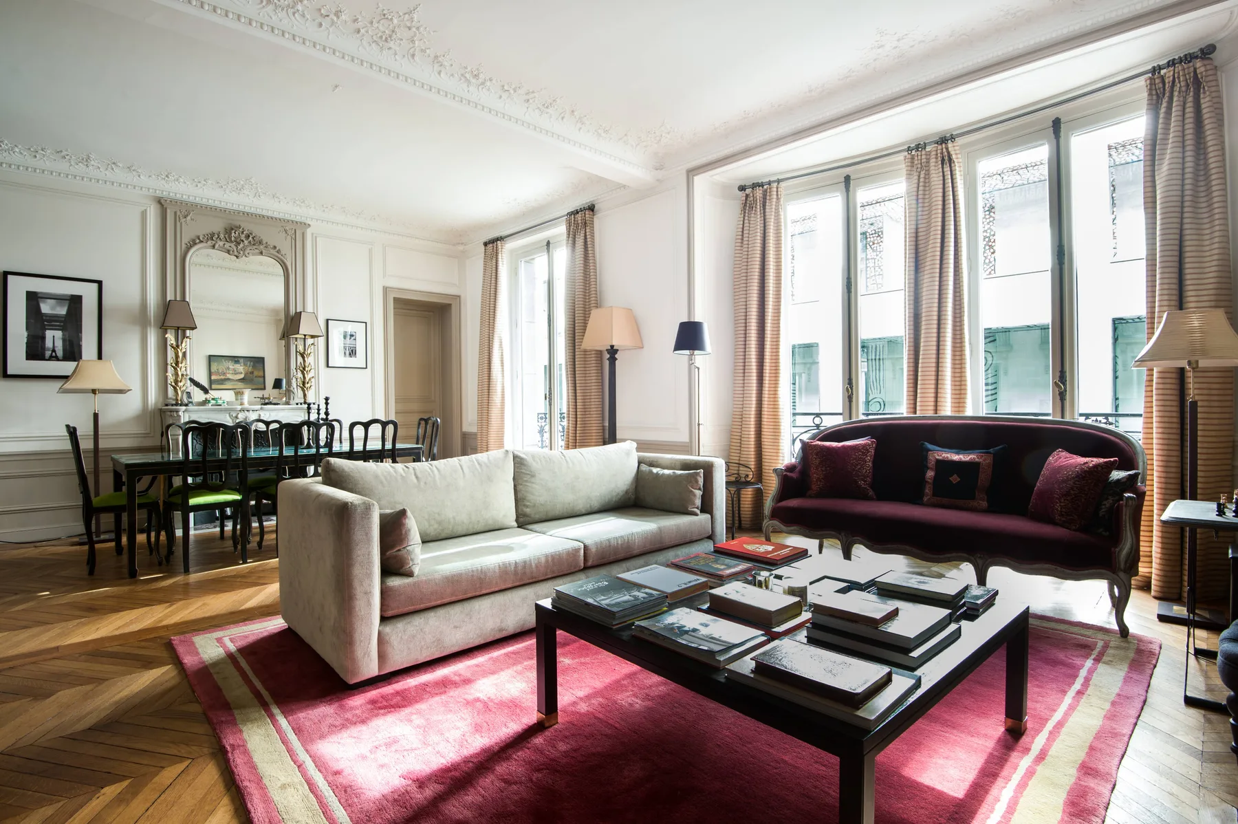 A bright living room with seating, a coffee table, and a dining area.