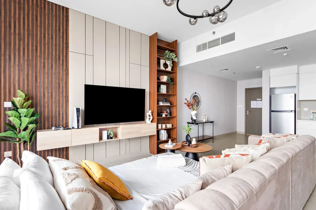 A modern living room with a television wall and a large sectional seating area.