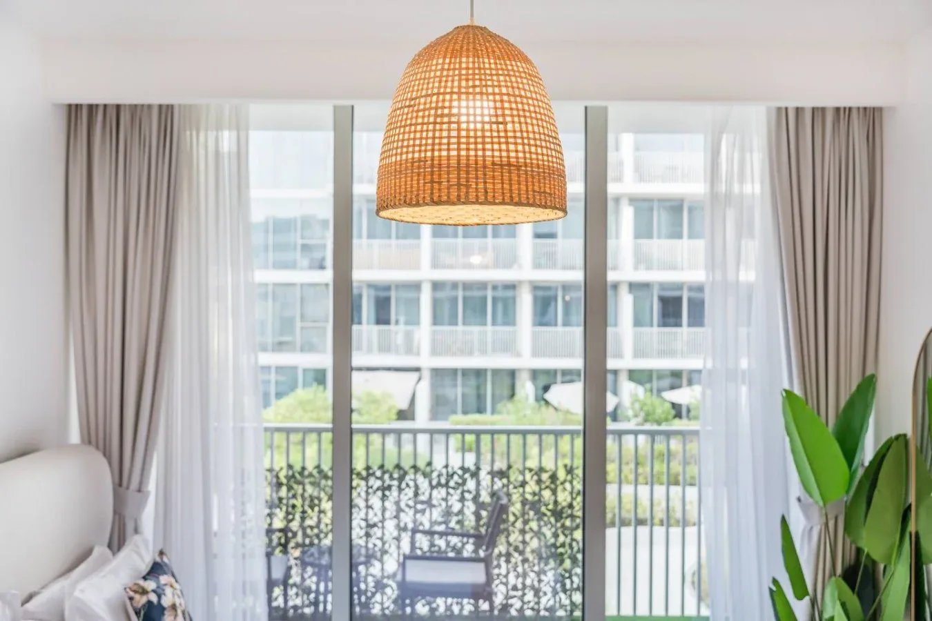 A bright living area opens onto a balcony through large glass doors.
