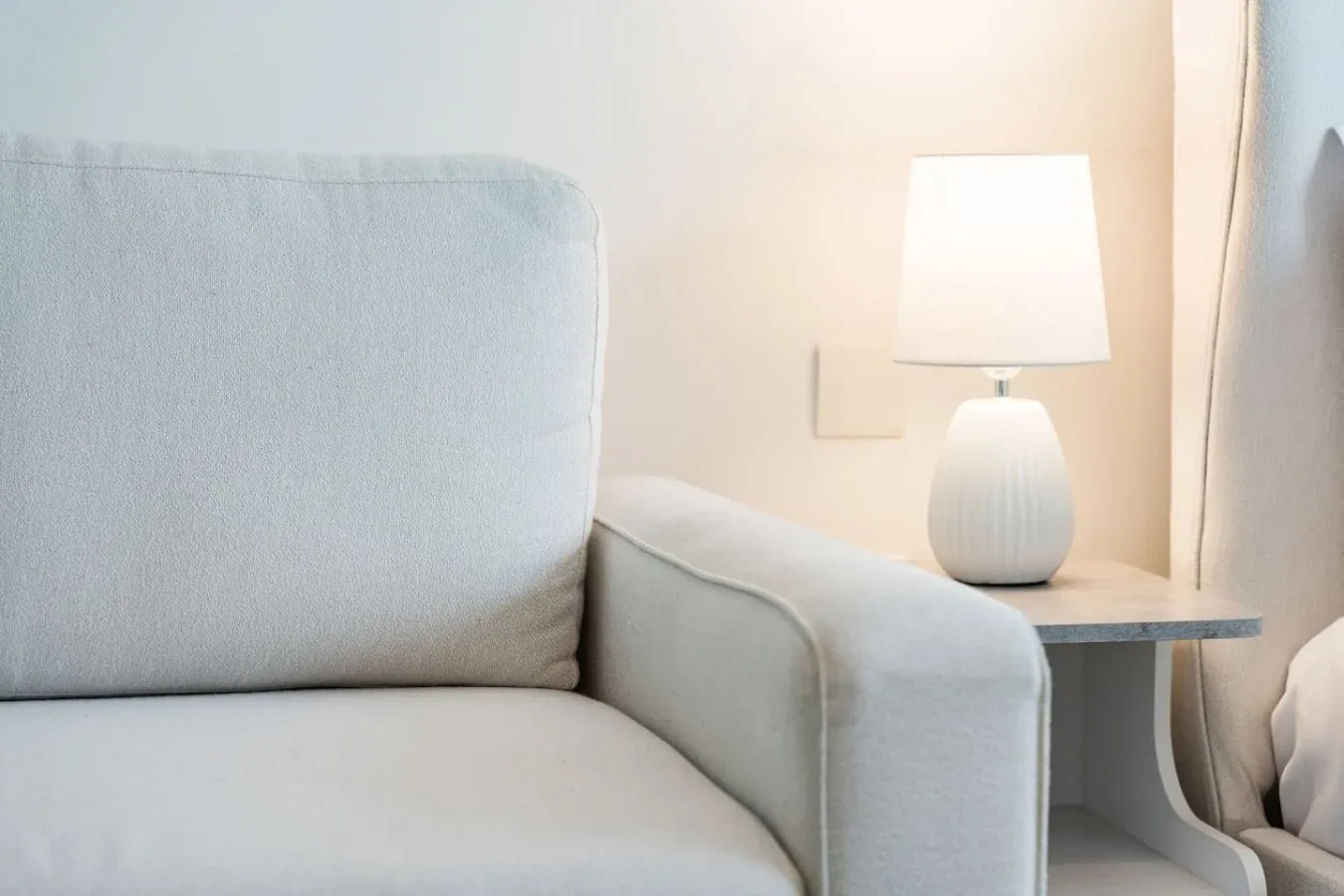 A seating area beside a side table with a lit lamp.
