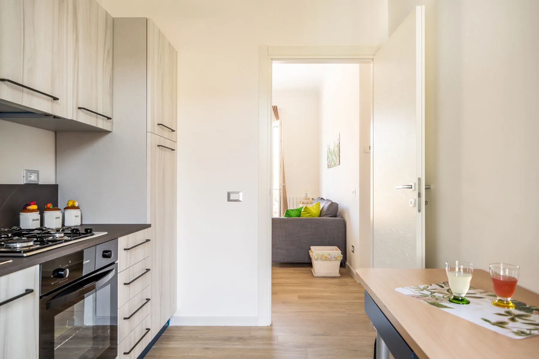 Una cocina se abre a una pequeña sala de estar, con una mesa de comedor en primer plano.