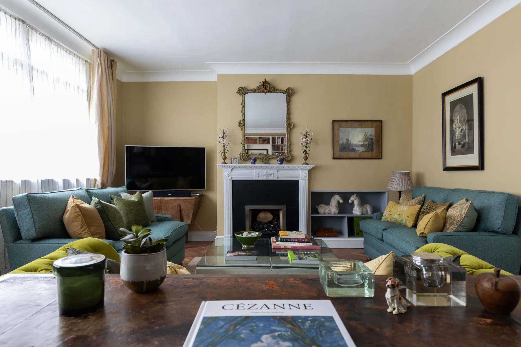 A living room with seating arranged around a fireplace and coffee table.
