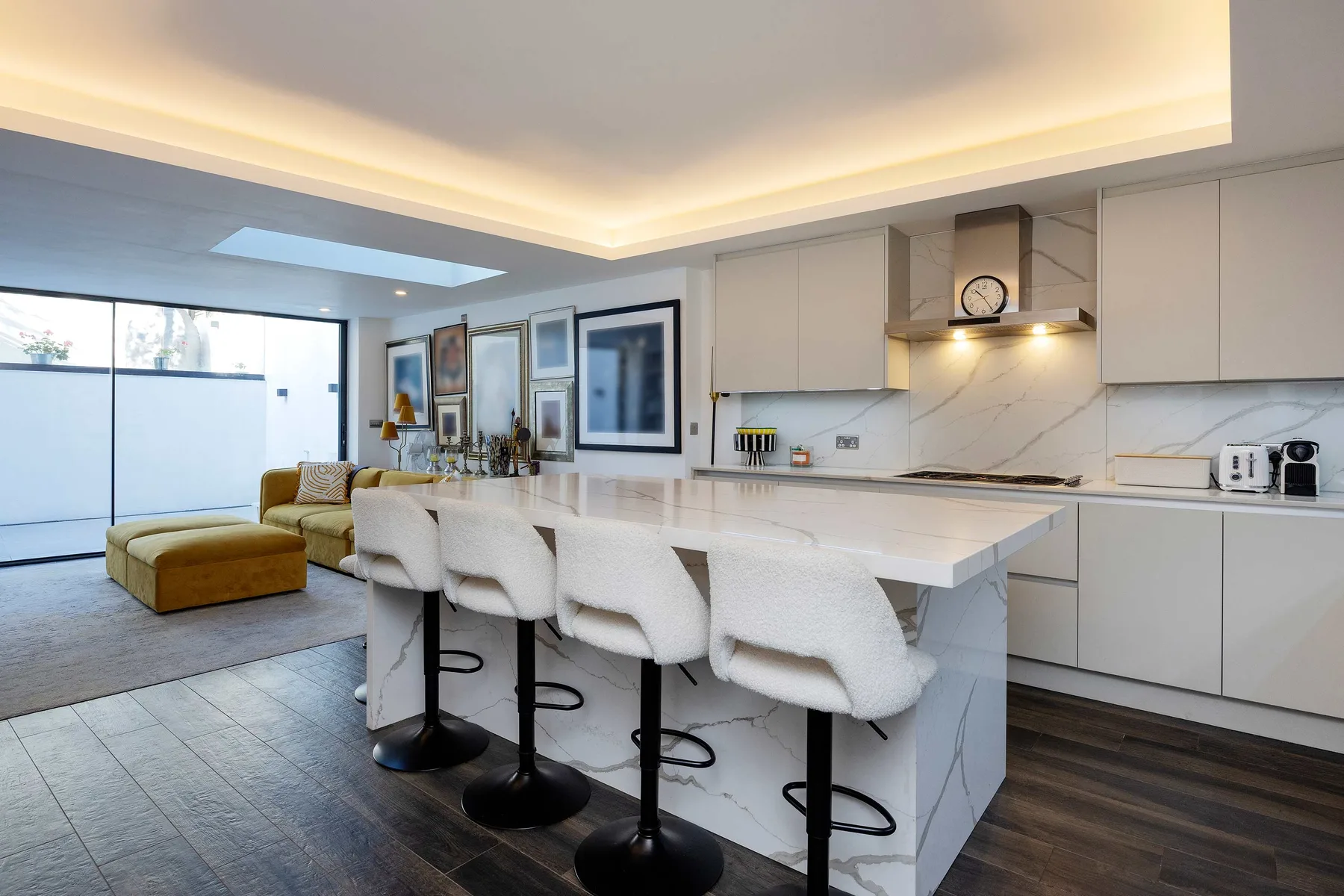 A bright open-plan kitchen with a large island and white seating.