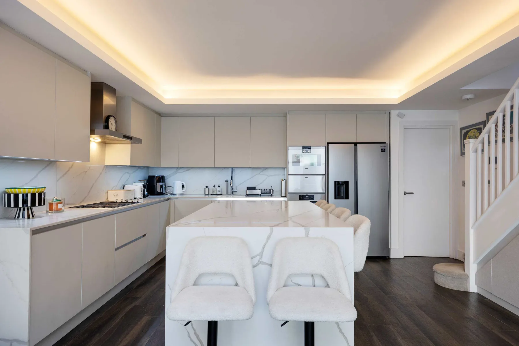 A modern kitchen and dining area with a central island and seating.