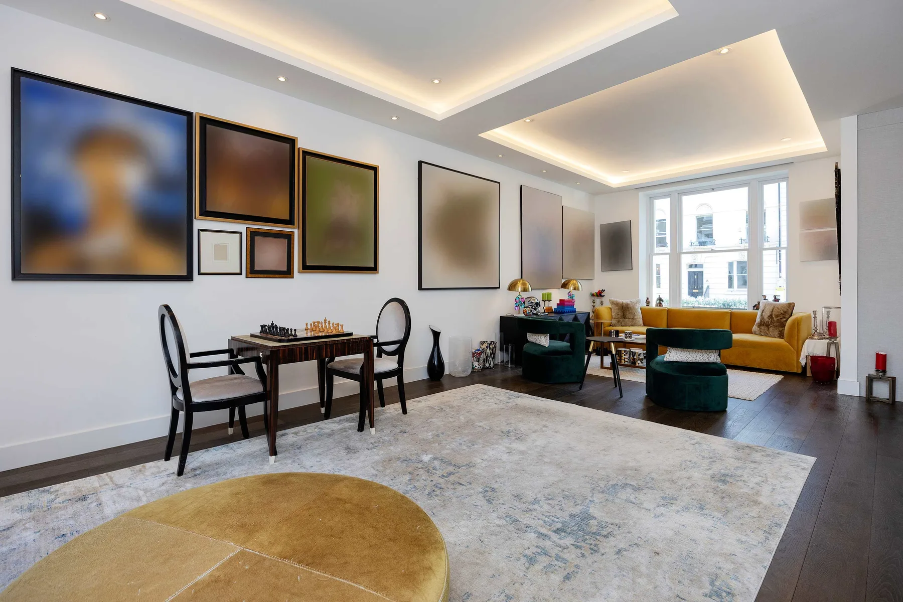 A bright living room with a dining table, seating, and large windows.