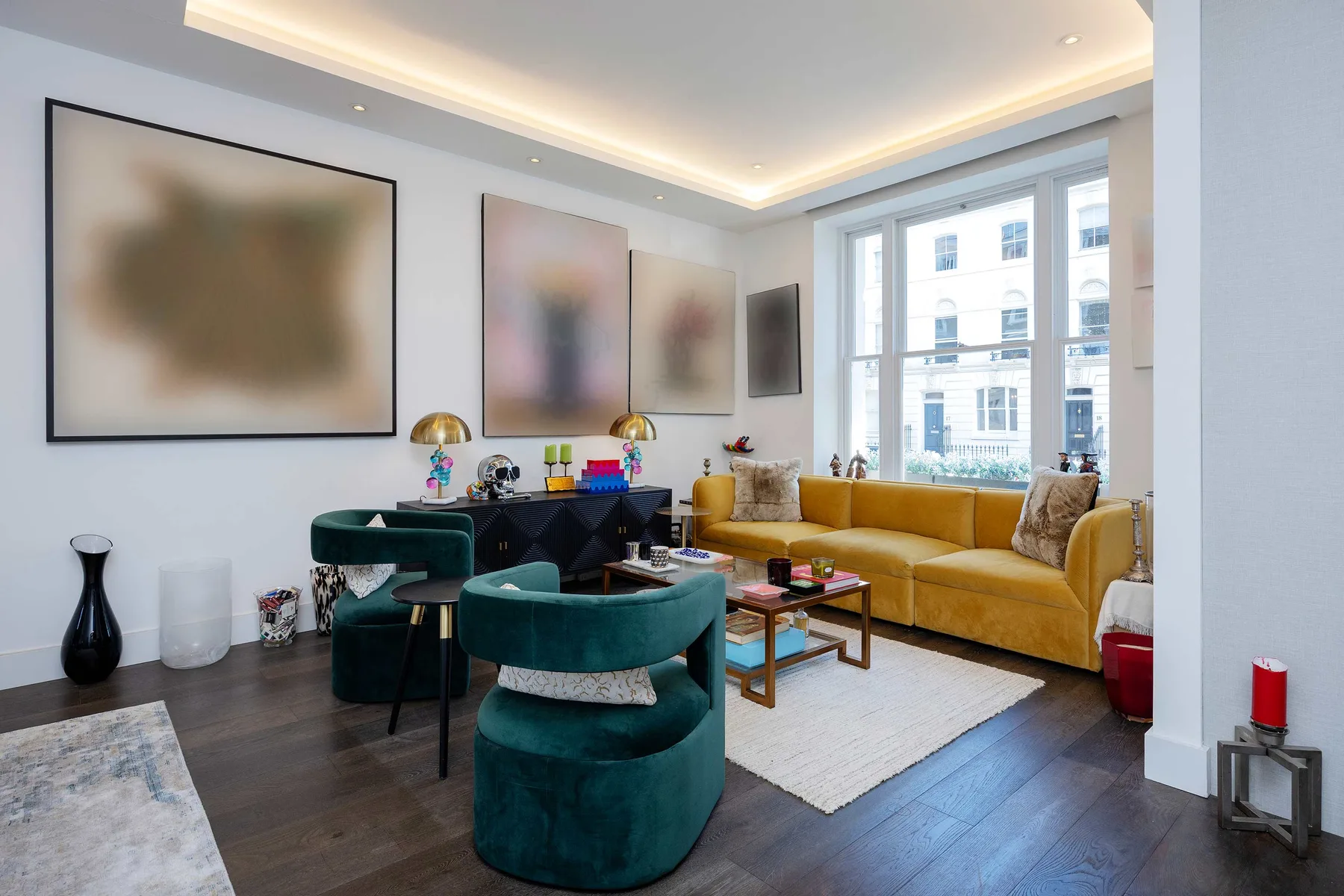 A bright living room with seating arranged around a coffee table beside large windows.