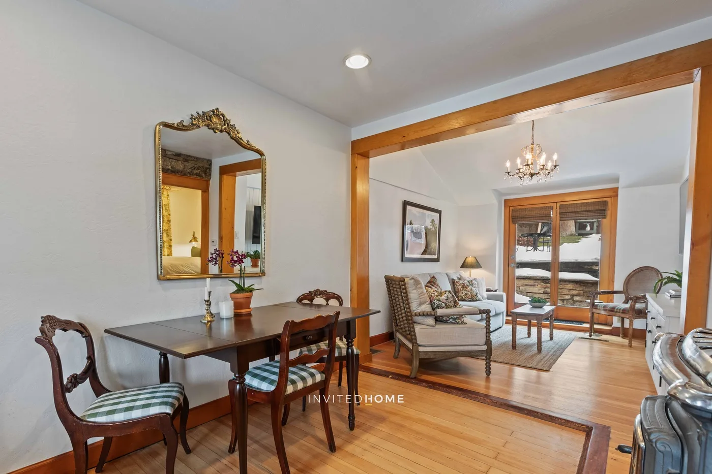 A living and dining room with a table, seating, and large windows.
