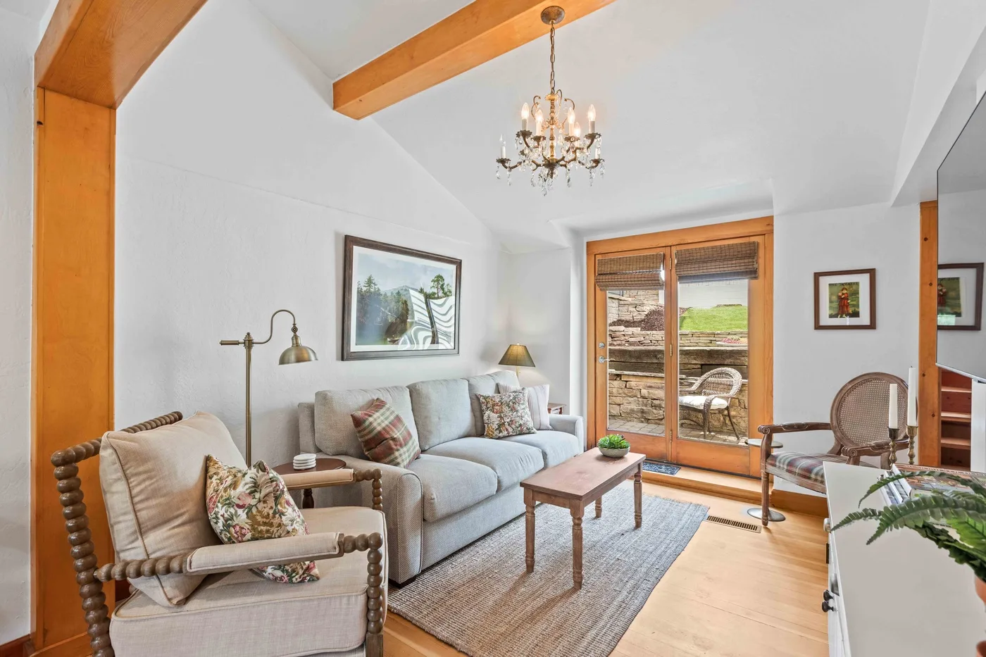 A bright living room with seating around a coffee table and glass doors.
