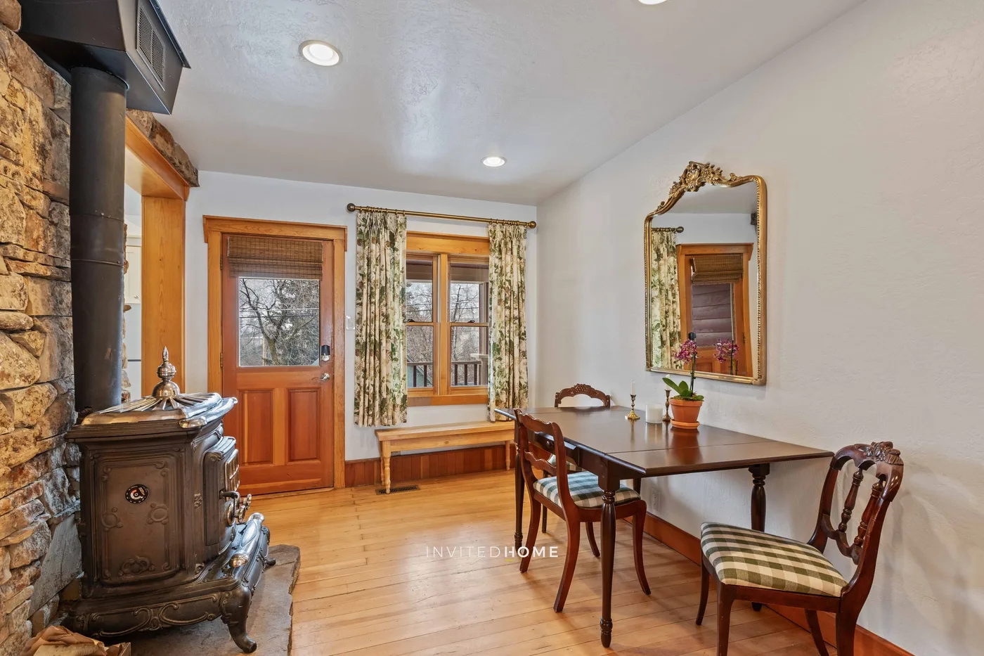 A dining area with a wooden table and chairs beside a window.
