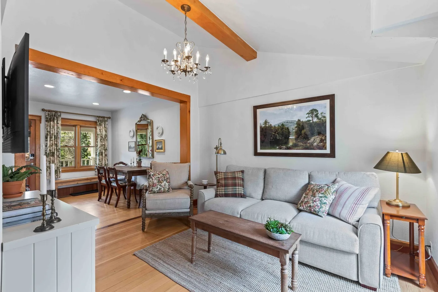A bright living room with a gray seating area and a wooden coffee table.