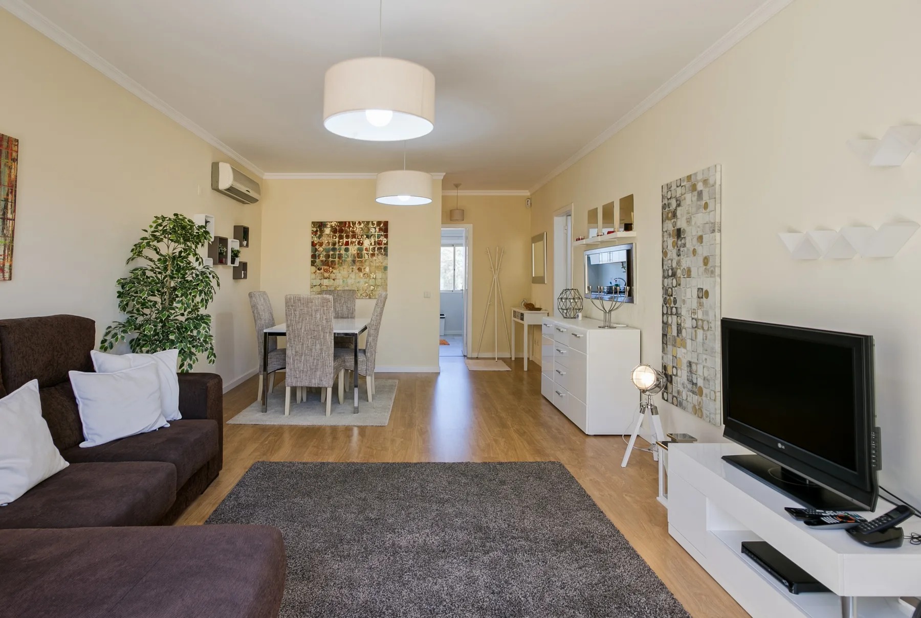 A living and dining room with seating, a television, and a dining table.