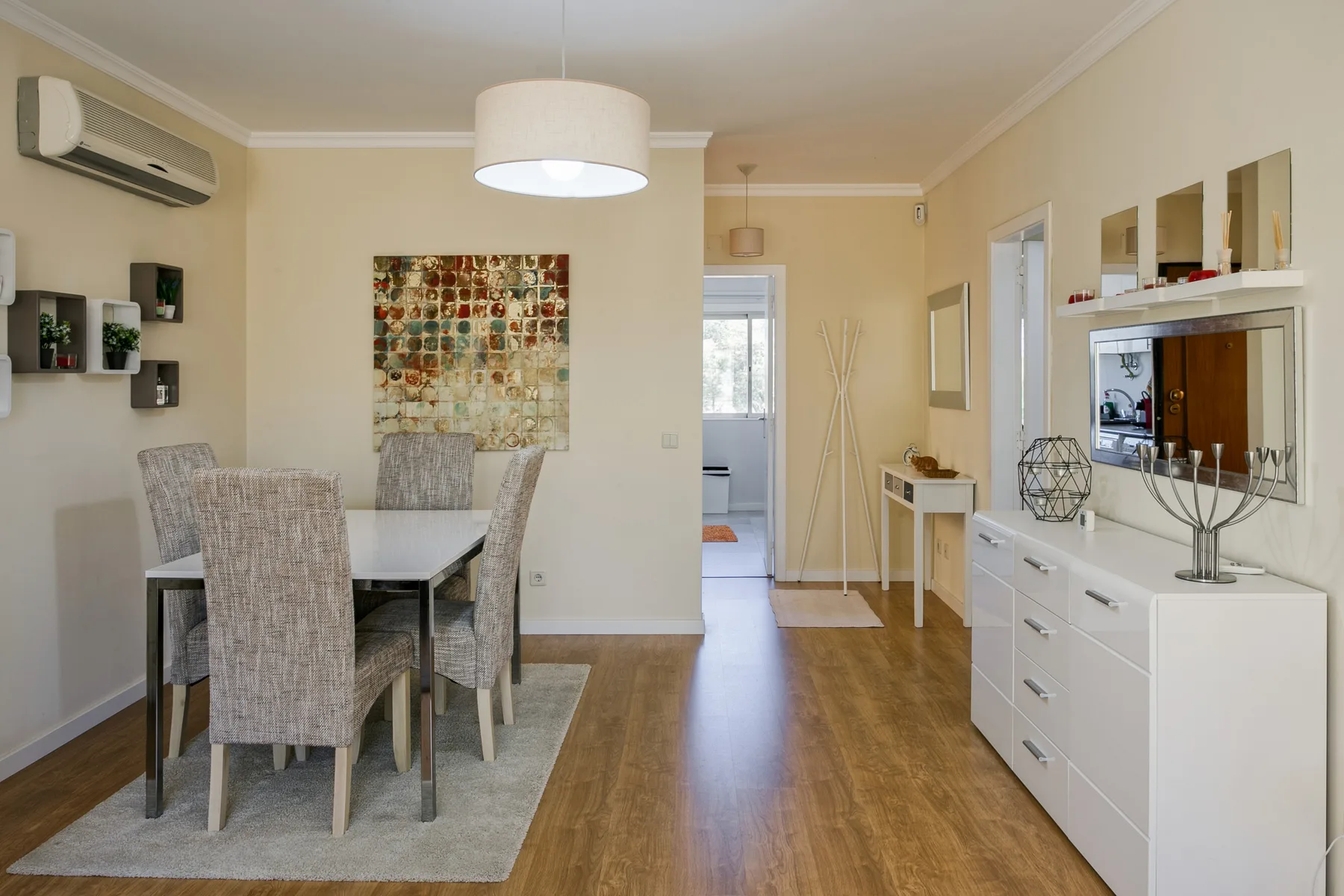 Dining and living area with a table, seating, and white storage furniture.