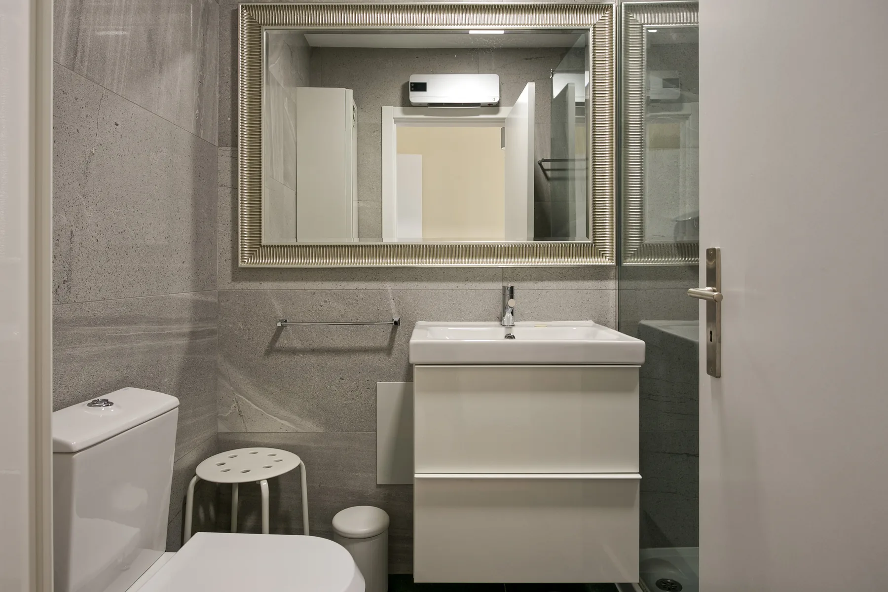 A bathroom with a sink, mirror, and toilet.