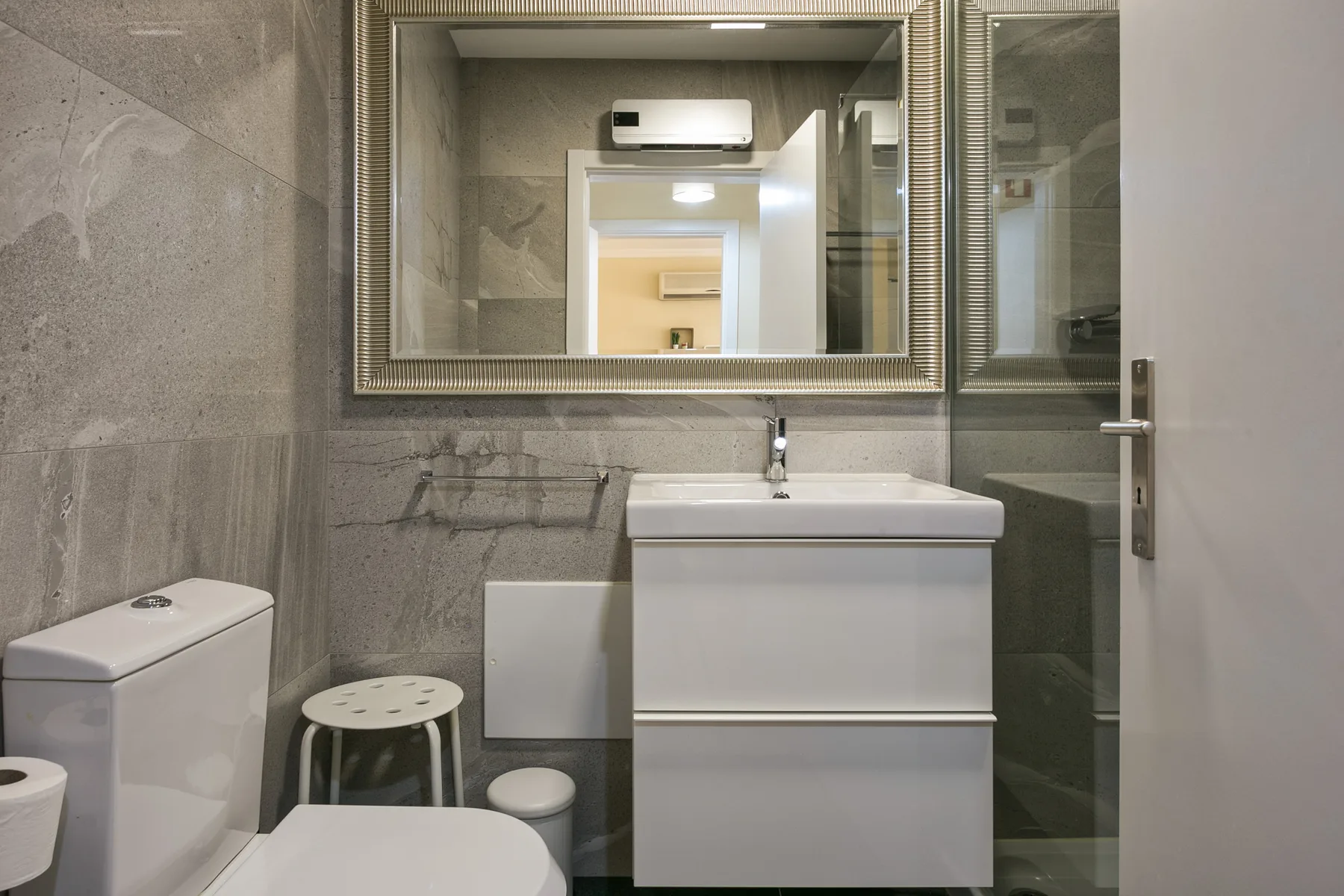 A bathroom with a sink, large mirror, and shower.