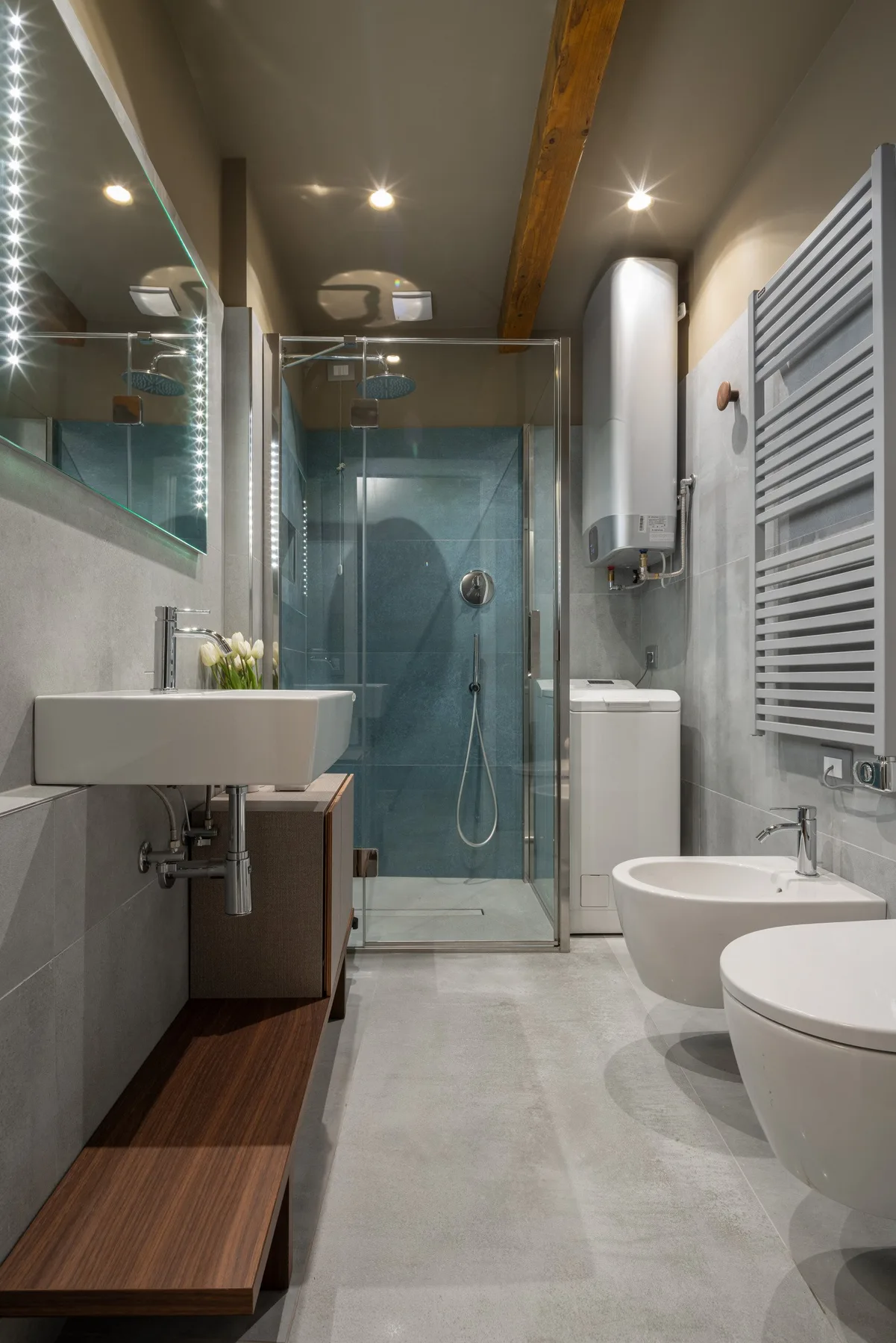 Un baño moderno con ducha acristalada y lavabo de pared.