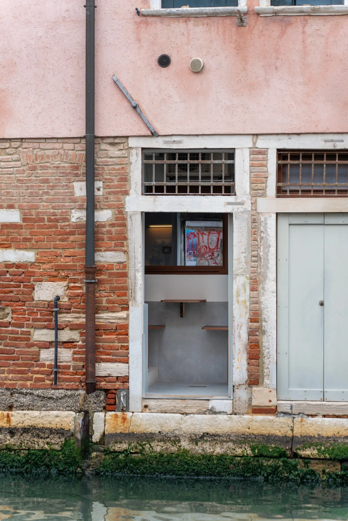 Una puerta estrecha da a un pequeño interior junto a un canal.