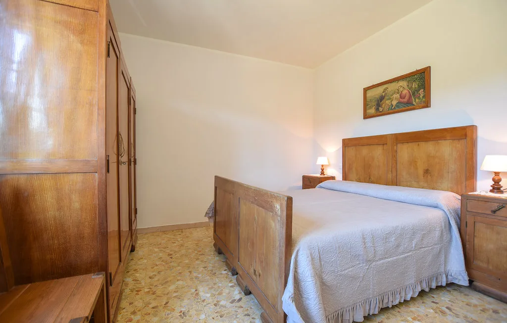 Un dormitorio con una cama de madera, armarios y ropa de cama clara.