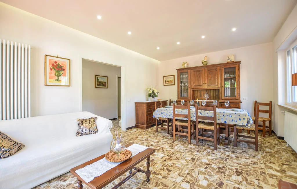 Un luminoso comedor y sala de estar con una mesa larga y asientos blancos.