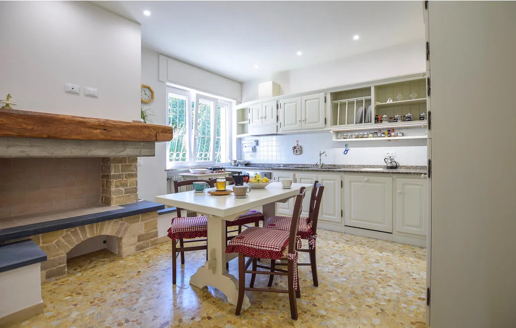 Una cocina luminosa con una mesa de comedor y una chimenea de ladrillo.