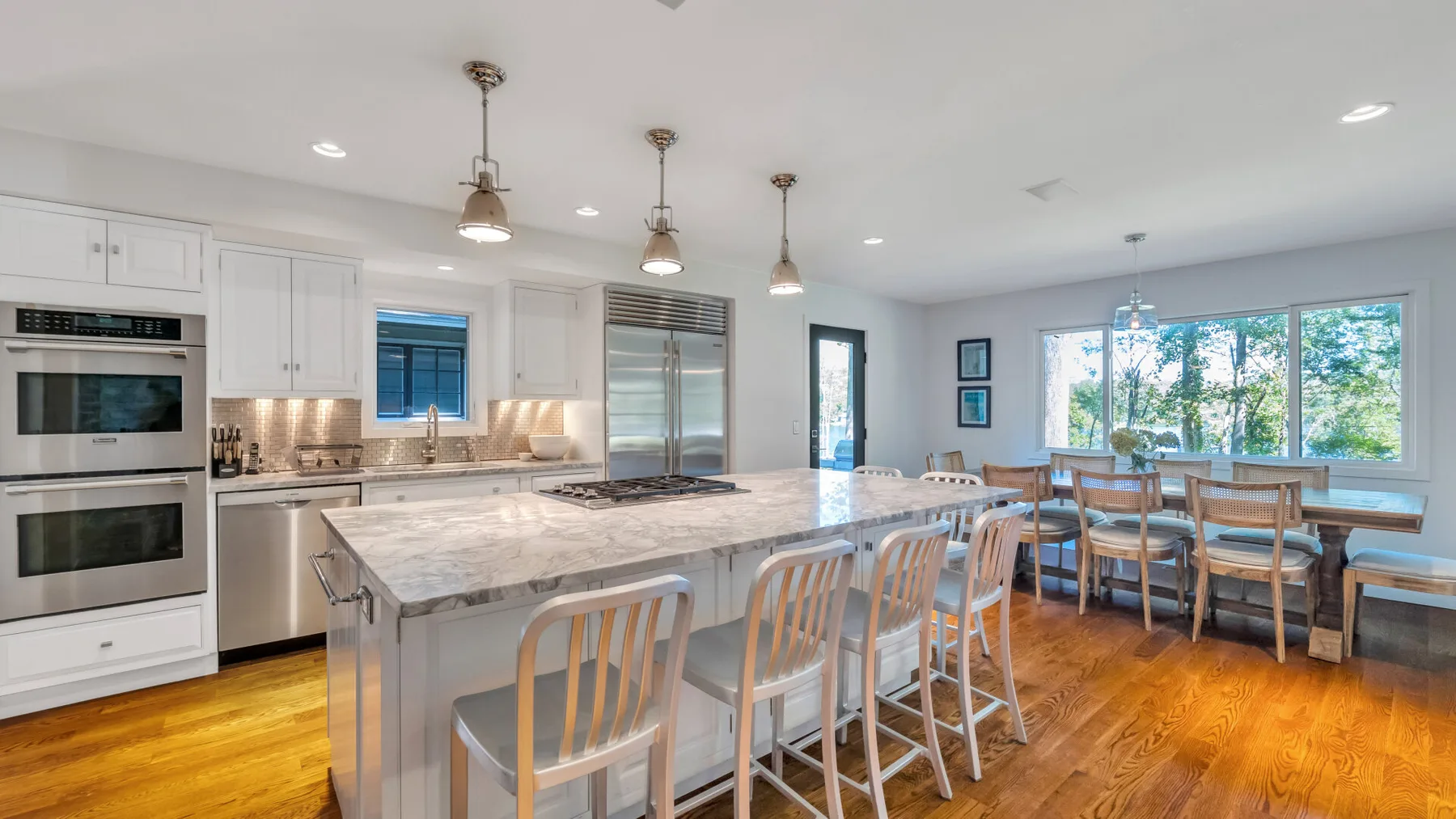 A bright kitchen and dining area with a large island and windows.
