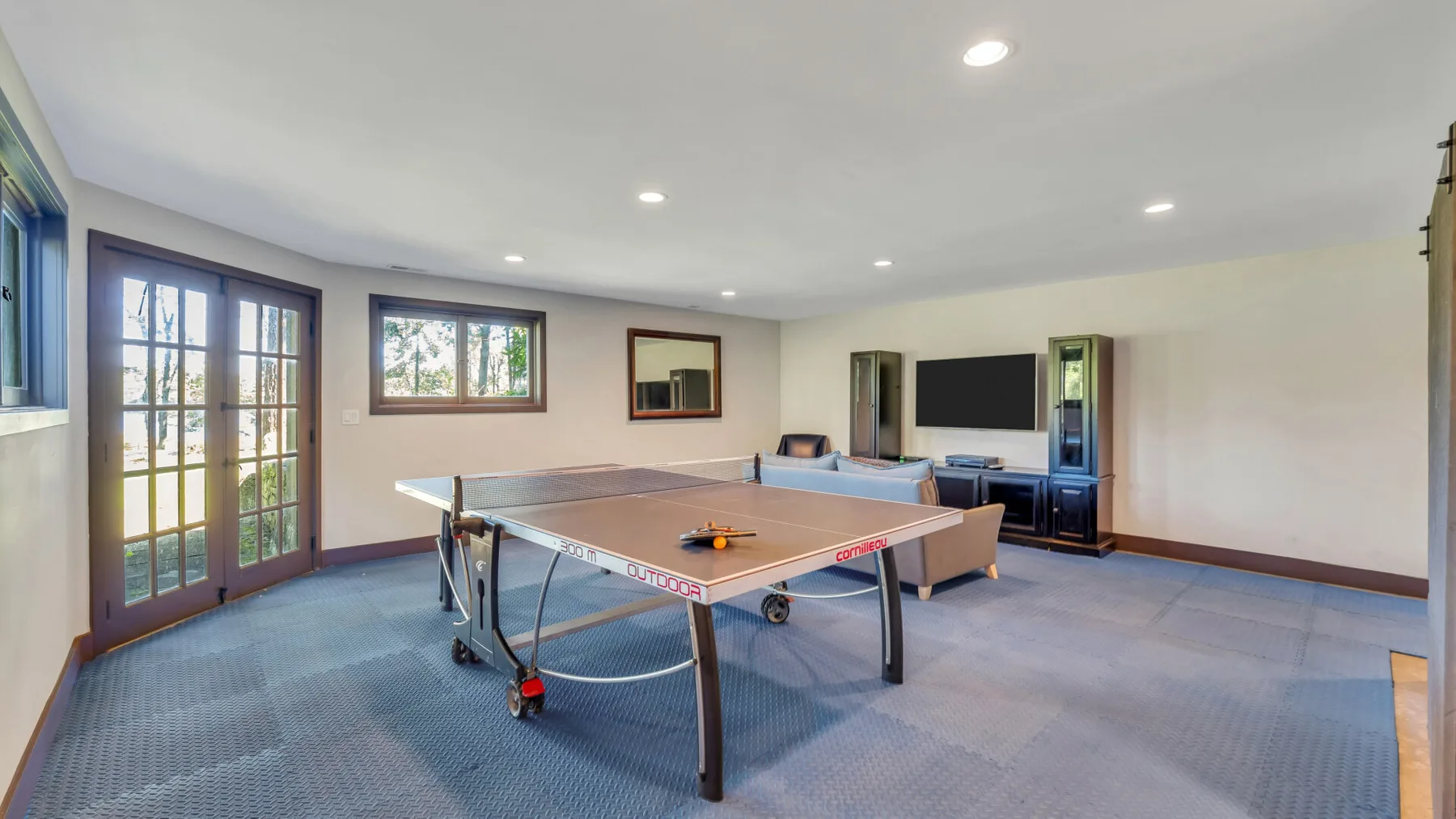 A game room with a ping-pong table and television.