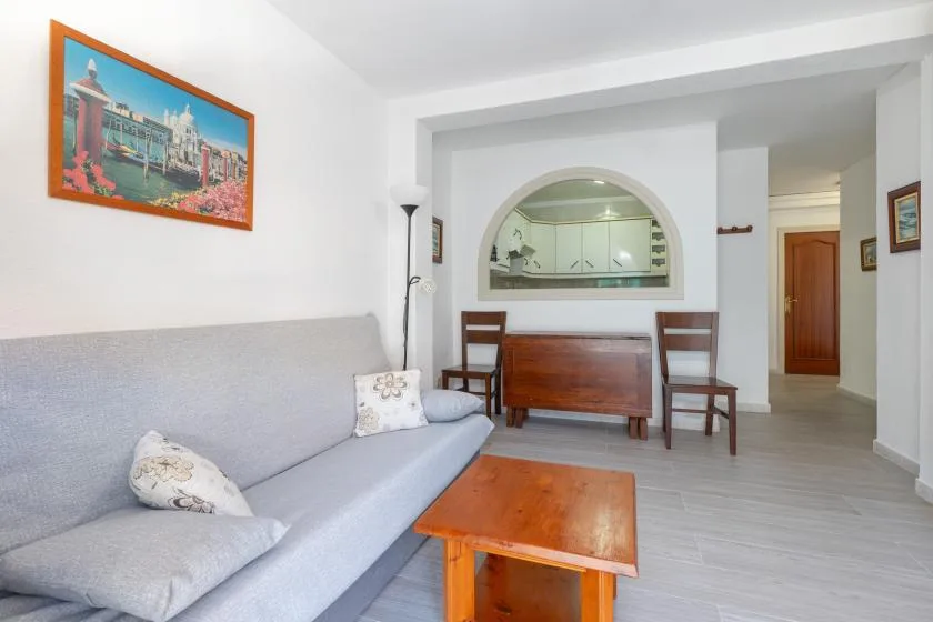 A bright living room with gray seating and a wooden coffee table.