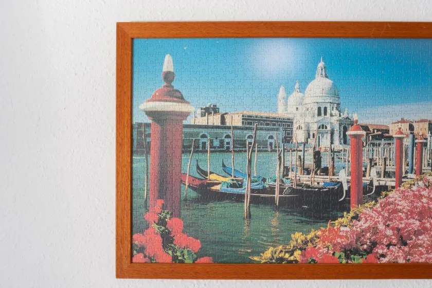 A framed picture of a Venetian canal hangs on a light-colored wall.
