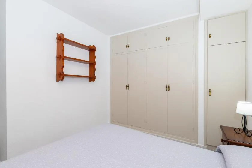 A bedroom with built-in cabinets and a bed.