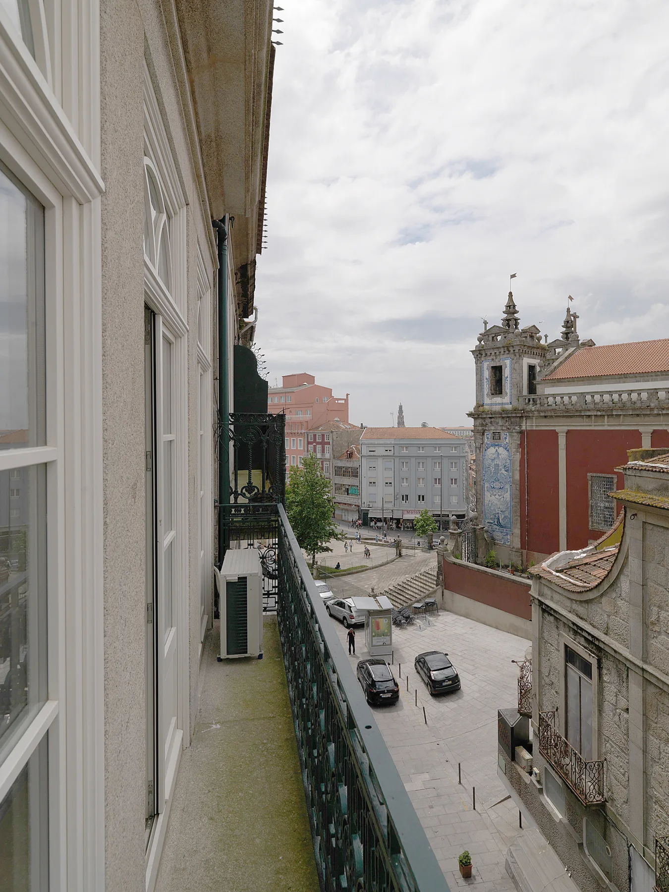 A balcony overlooks a city square and nearby historic buildings.