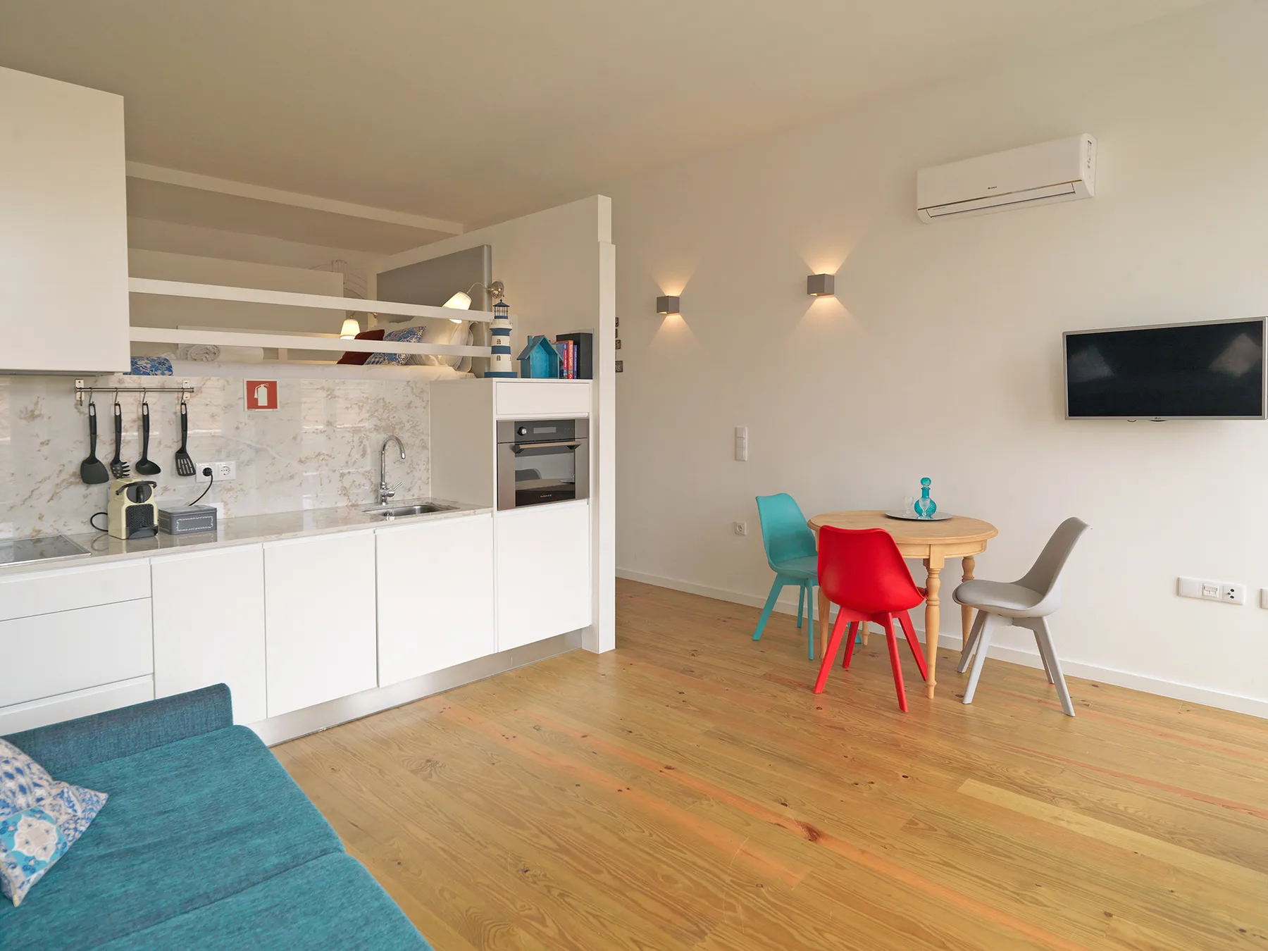 Studio interior with a kitchen counter, seating area, and small dining table.