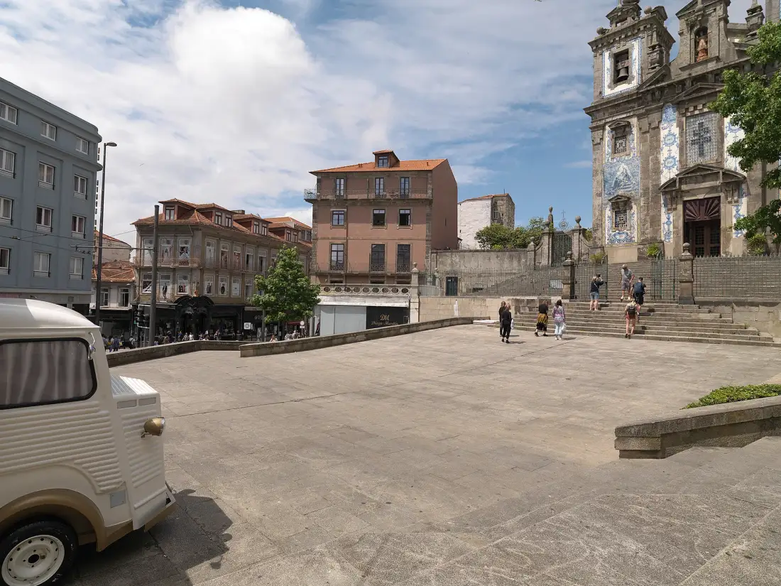 A paved city square with historic buildings and a church façade.