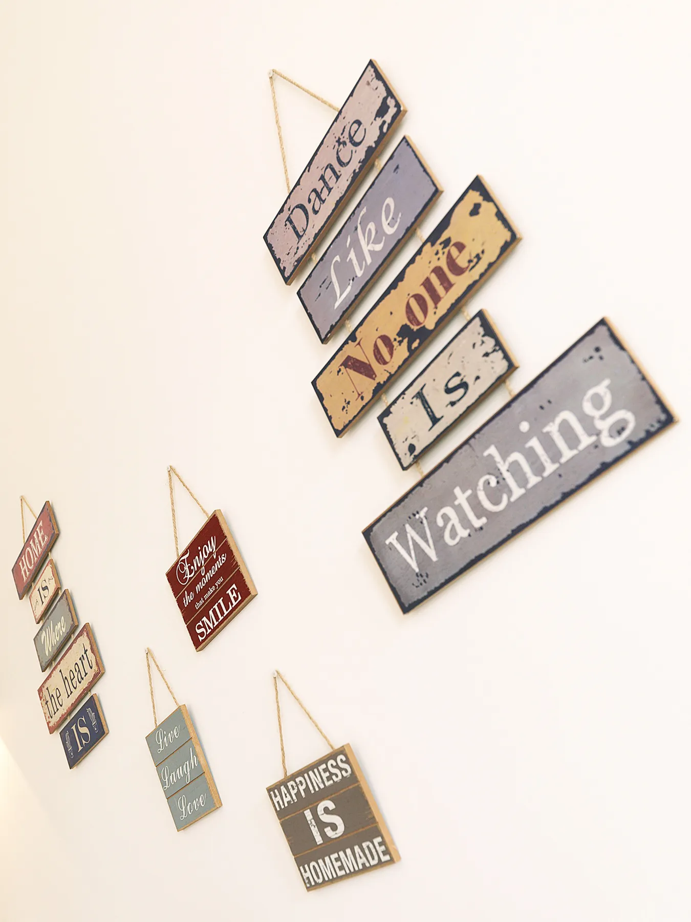 Decorative wall signs with inspirational words hang against a light-colored wall.