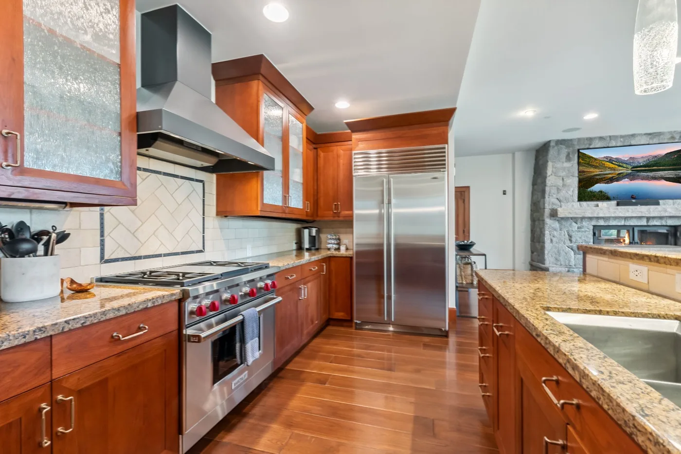 A spacious kitchen with wood cabinetry, stainless steel appliances, and a central island.