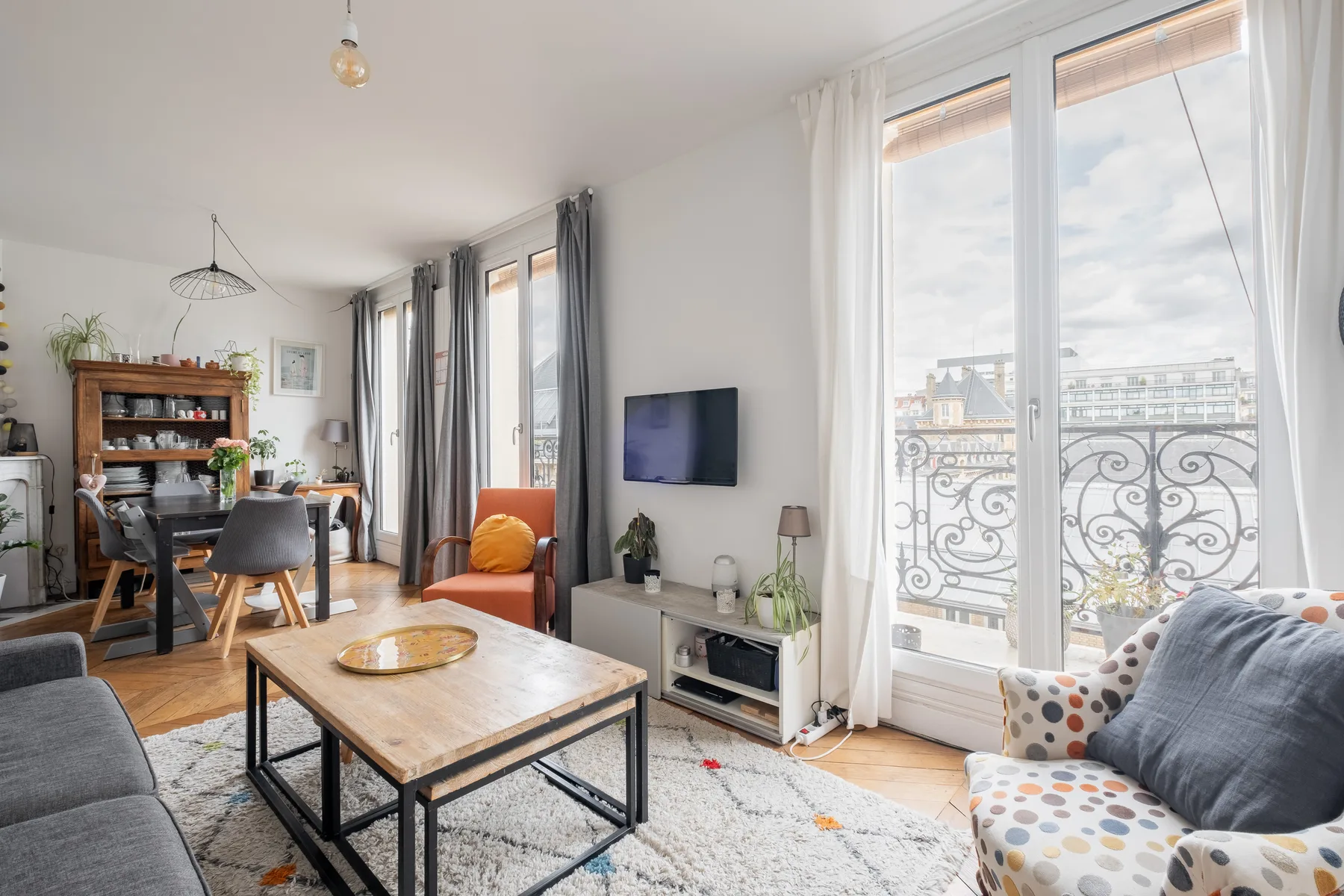 Una sala luminosa con una mesa de centro, asientos y grandes ventanas.